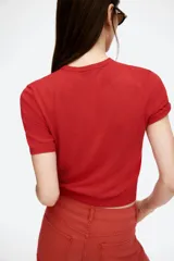 Remera de punto fino color rojo, de corte entallado, con cuello redondo y mangas cortas.