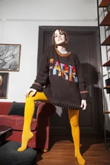 Sweater tejido de lana marrón con cuello redondo y puños acanalados. Presenta un estampado con la palabra 'FARRA' en letras de colores.