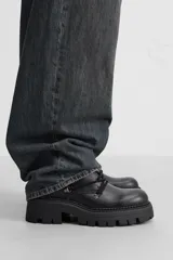 Bota de cuero negra con cordones, cordonera con nueve pasados, tirador trasero y suela track con volumen.