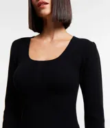 Vestido corto negro de punto con escote cuadrado y mangas largas.