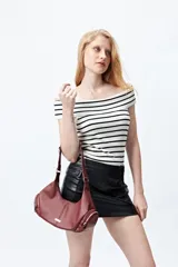 Minifalda negra de cuero sintético con botones decorativos laterales y bolsillo con solapa.