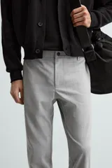 Pantalón largo de vestir gris claro con estampado de cuadros, corte slim fit y cintura elástica. Confeccionado en tejido con alta elasticidad, bolsillos frontales y cierre frontal con cremallera y botón.