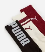 Kit de tres pares de medias deportivas Puma de caña larga. Un par color beige con dos rayas marrones horizontales en la parte superior y logo marrón en el tobillo. Un par color crema liso con logo blanco en el tobillo. Un par color marrón con una raya blanca horizontal en la parte superior y logo blanco en el tobillo.