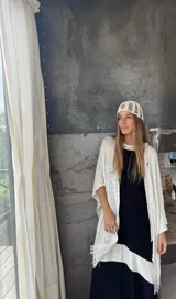 Ruana tejida a mano en color amarillo, de diseño liviano con flecos en el ruedo. Confeccionada en hilo, presenta un punto abierto y fluido.