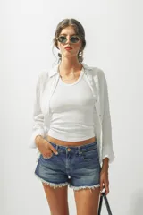 Camisa blanca de lino de manga larga con cuello clásico y cierre frontal con botones.