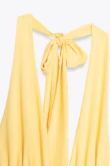 Vestido largo amarillo con escote halter y espalda descubierta, atado al cuello.