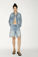 Bermuda de jean celeste de tiro medio con cinco bolsillos. Detalle de trabilla ajustable en espalda. Bajo con terminación desflecada. Cierre frontal con botones metálicos.