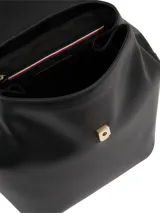 Mochila negra de poliuretano con forro de poliéster. Presenta un diseño estructurado con solapa superior que cierra con broche magnético y un asa de mano superior. En el centro de la solapa lleva un monograma metálico TH.