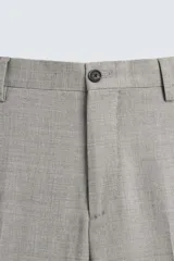 Pantalón de vestir gris claro, de corte recto, confeccionado en tejido con lana. Cuenta con bolsillos frontales y traseros de doble vivo con botón. Cierre frontal con cremallera y botón.