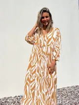 Vestido largo tipo túnica con estampado de cebra en tonos beige y crudo, con cuello en V y mangas 3/4.