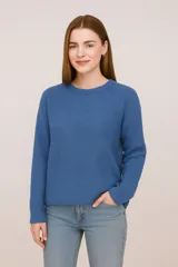 Sweater de tejido punto color blanco roto, de manga larga y cuello redondo, con calce holgado.