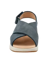 Sandalias de cuero azul con tiras cruzadas y ajuste con velcro en el tobillo. Suela de goma blanca con plantilla color piel.