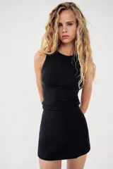 Falda pantalón corta negra de tiro medio con corte asimétrico.