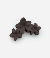 Pinza para el pelo color marrón oscuro con tres flores de plástico.