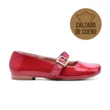 Zapato de cuero rojo charol, con punta cuadrada, tira sobre el empeine con hebilla metálica y taco bajo.