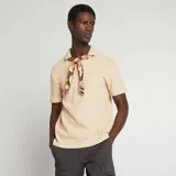 Remera de hombre color beige claro, de punto piqué, con cuello polo y mangas cortas.