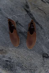 Mocasines marrones de cuero con elásticos laterales y tirador trasero.