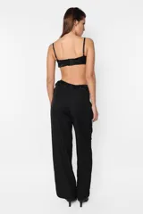 Pantalón sastrero negro, de calce tiro bajo y fit Relax. Con pinzas en delantero, detalle de cintura deshilachada y cartera de acceso curva. Presillas y bolsillos escondidos en los laterales.