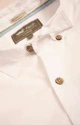 Camisa amarilla de algodón orgánico, manga larga con botones de madera, cuello italiano, calce regular, bolsillo de pecho con logo bordado.