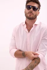 Camisa de vestir rosada de manga larga, con cuello clásico y cierre frontal con botones.