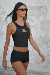 Top de lycra negro con forro, corte hasta la cintura, escote redondo y detalle de abertura con hebilla en el frente.