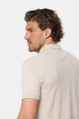 Remera polo azul de piqué liso, con cuello de rib y botones personalizados.