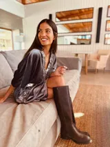 Vestido corto gris de terciopelo con escote en V y flecos de lentejuelas plateadas.