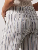 Pantalón de lino a rayas verticales grises y blancas, con pretina elastizada, lazo de ajuste y bolsillos delanteros y traseros.