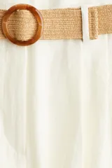 Short blanco de tiro alto con pinzas, bolsillos laterales y traseros. Incluye cinturón trenzado con hebilla redonda.