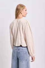 Blusa color crudo de manga larga con detalles de puntilla.