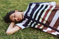 Camisa negra de algodón con cuello mao y mangas cortas. Presenta un pequeño bordado de una flor blanca en el pecho.