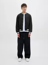 Campera bomber negra con cuello tipo baseball y puños de canalé. Cierre frontal con botones a presión y bolsillos laterales.