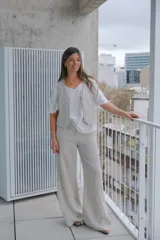 Conjunto de chaleco y pantalón de lino color beige. El chaleco es entallado con cuello en V y abotonadura frontal. El pantalón es de corte palazzo con cintura alta.