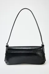 Bolso de hombro negro acharolado con solapa y asa ajustable. Cierre con imán.