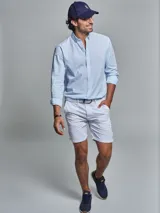 Bermuda blanca de algodón y poliéster, corte regular fit, con cinturón, dos bolsillos delanteros, dos bolsillos traseros, un bolsillo relojero y botamanga con presilla.