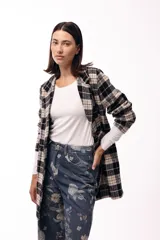 Jean de corte wide leg y tiro alto, confeccionado en denim azul oscuro con estampado floral en tonos suaves. Presenta diseño de cinco bolsillos y cierre frontal con botón.