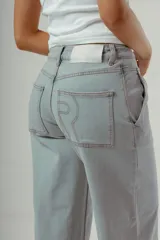 Pantalón de denim color marrón oscuro, tiro medio, con silueta wide leg y costuras verticales marcadas en el frente de ambas piernas.