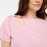 Remera rosa de algodón con cuello redondo y manga corta. Presenta un corte en el hombro que crea una abertura con efecto retorcido.