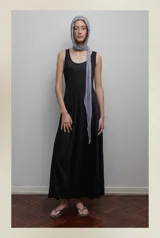 Vestido largo negro de corte evasé, sin mangas y escote redondo. Incluye un pañuelo gris claro.