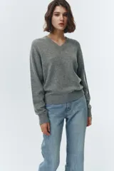 Sweater de tejido de punto color gris, con escote en V y puños y bajo elásticos.