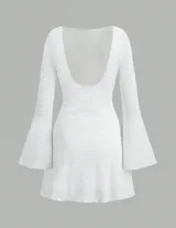 Minivestido blanco de manga larga acampanada, con cinturón marrón de cuero con apliques metálicos.