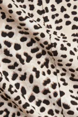 Vestido midi de manga larga con estampado animal en tonos beige y negro.
