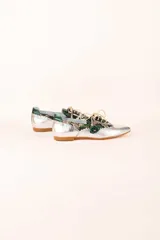 Zapato blucher plateado con estampado animal print, cordones y detalle de flor en el final del cordón. Interior 100% piel y suela de cuero. Incluye plantilla de lana y piel.