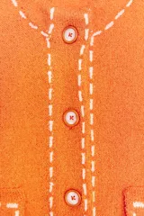 Chaqueta naranja de punto con cuello redondo y manga corta. Presenta bolsillos delanteros de parche con solapa y cierre frontal con botones. Detalle de pespuntes blancos a contraste.