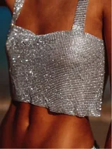 Top plateado de metal con strass, escote cuadrado y tirantes finos. Se ajusta con cadena en la espalda.