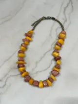 Collar corto con cadena de eslabones color bronce y piedras irregulares color amarillo y marrón.