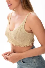 Top crop tejido al crochet color dorado, con breteles finos y terminación con flecos.