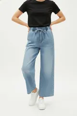 Pantalón de jean azul claro, de corte holgado y tiro alto, con cintura elástica y cordón ajustable.