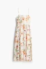 Vestido midi blanco con estampado de flores en tonos naranja y rosa, breteles finos y escote cuadrado.