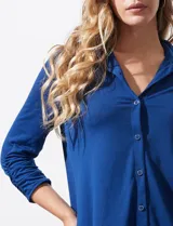 Camisola blanca de manga tres cuartos, marca Rio & Rian. Cuello con solapa y abertura central con botones. Manga con detalle fruncido.